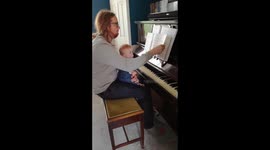 Baby waits for page to turn before playing piano