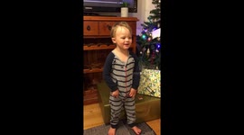 Christmas 3 year old singing in front of Christmas tree