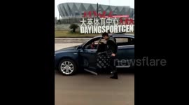 Chinese man marches next to moving car