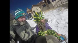 Little Girl Dressed as Dinosaur sledding