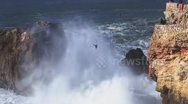 Nerve-racking slackline walk over huge waves in Nazaré, Portugal