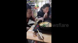 Man pranks friend playing on phone while eating hotpot