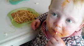 Messy toddlers eating spaghetti