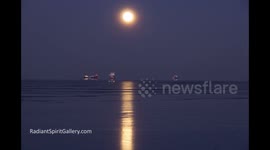 New Year's Day Supermoon rising over Lake Superior and icy ships; timelapse video