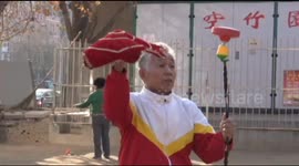 Elderly Chinese man plays diabolo on unicycle
