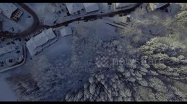 Aerial, beautiful woods under the snow and the view on the snowy mountains with little villages in winter