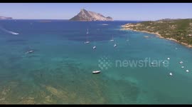 Aerial, beautiful bay in Sardinia with a beach and some anchored boats and yachts