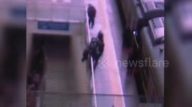 Police grabs man jumping off guardrails at train station