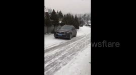SUV slides dangerously down snow-covered road in China
