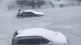 Parked cars trapped in frozen floodwater during US 'bomb cyclone'