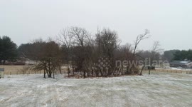 Drone flies over trees during snowstorm in Maryland