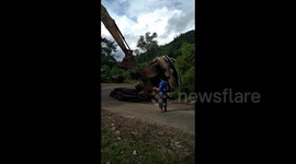 Excavator wakes his friend who is 'asleep' on the road