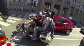 A rider and a passenger carry a lot of food and a guitar on a motorcycle for a BBQ