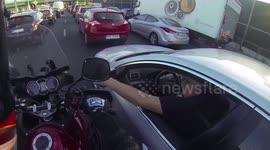 Driver folds his mirror to let a filtering rider pass in traffic