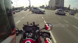 Driver runs a red light and cuts a motorcyclist off