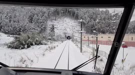 Train travelling on snow covered tracks passing through a tunnel