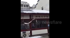 Snow falls off roof in central China