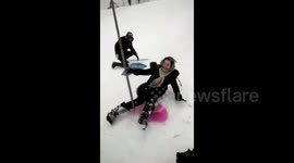 Woman knocks down tree in hilarious snow sledding fail