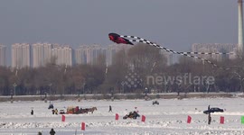 Chinese kite being flown above frozen river