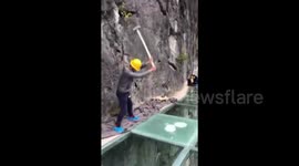 Men hit dizzyingly high glass walkway with sledgehammers