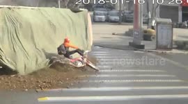 Motorcyclist escapes being buried by sand and stones pouring out of lorry