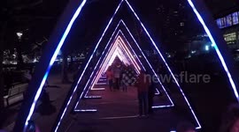 People walk through light sculpture in Lumiere London festival