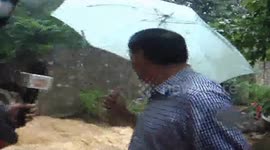 Floodwater rips down wall in middle of interview