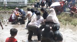 Indonesian women take part in tug of war contest in muddy paddy field