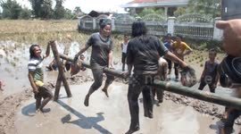 Two women whack each other with bags of rice in Indonesia game