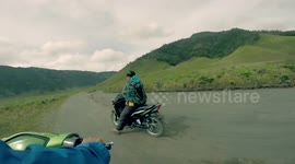Tourist goes for scooter ride at base of active Indonesia volcano