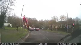 Car driving through red light as man was crossing