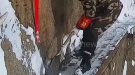 Workers sweep snow off 7000-ft high cliff in China
