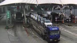 Overloaded truck knocks over toll booth with collector inside