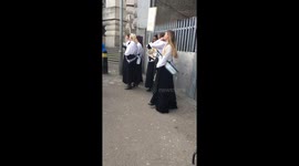 Women in suffragette costumes chant outside London’s Waterloo station