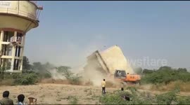 Narrow escape for driver after water tank falls on excavator during demolition