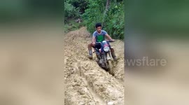 Motorbike riders in uphill struggle along muddle track