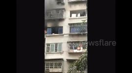Woman escape from window as flat in flame
