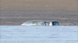 Stranded car rescued from beach mud