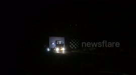 Liebherr crane company moving huge crane parts on narrow country roads at night to avoid traffic chaos