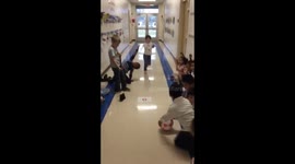 School teacher shows US first graders how to play curling in school corridor