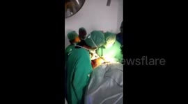 Indian doctors operate under mobile torchlight after power fails