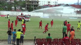 Watering a football field by a fire truck pursued by children
