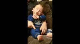 Sleeping baby  won't give up the rusk!