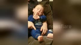 Newsflare Edit - Sleeping baby  won't give up the rusk!