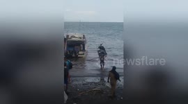 Man dashes to catch boat while carrying moped aloft