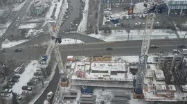 Highrise condo construction in snow with cranes