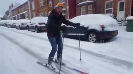 Man goes skiing down snow-covered road in England
