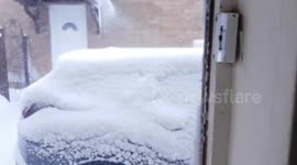 open's the door to see how bad the snow is