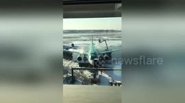 Airport workers defrost plane on Heathrow runaway