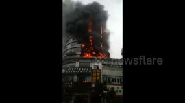 Ten-storey building bursts into flames in southern China